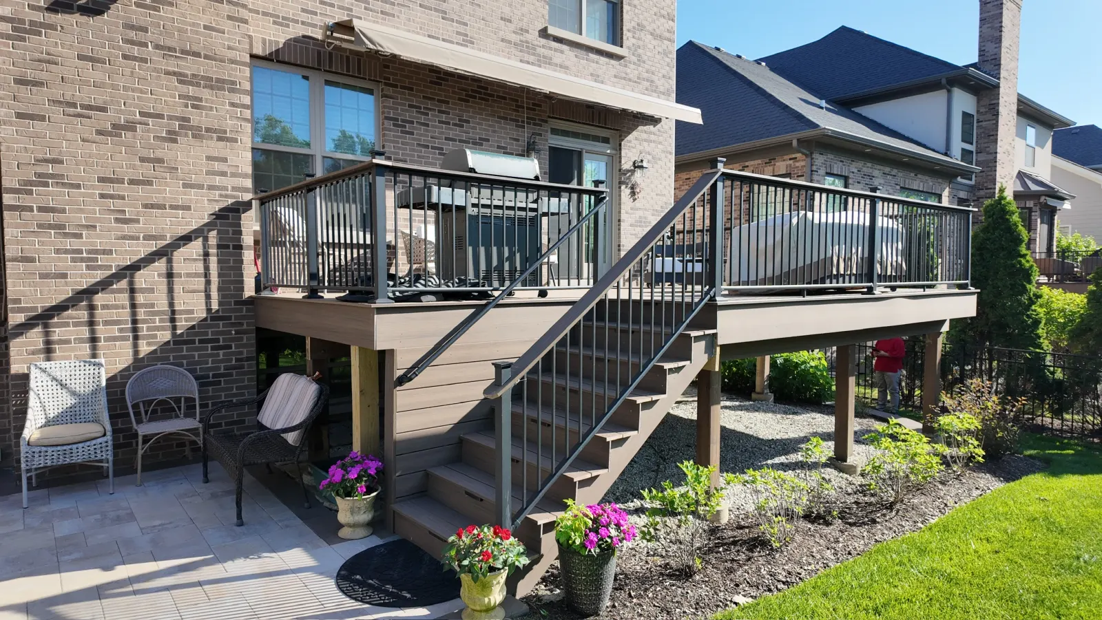 Completed composite deck with black aluminum railing and wide staircase