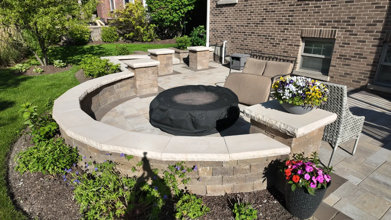 Curved Unilock paver patio with built-in fire pit and curved seating wall