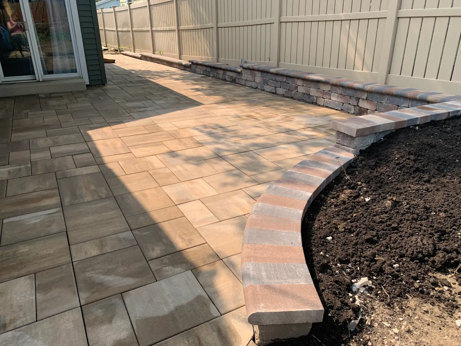 Unilock paver patio with curved seating wall installation in progress
